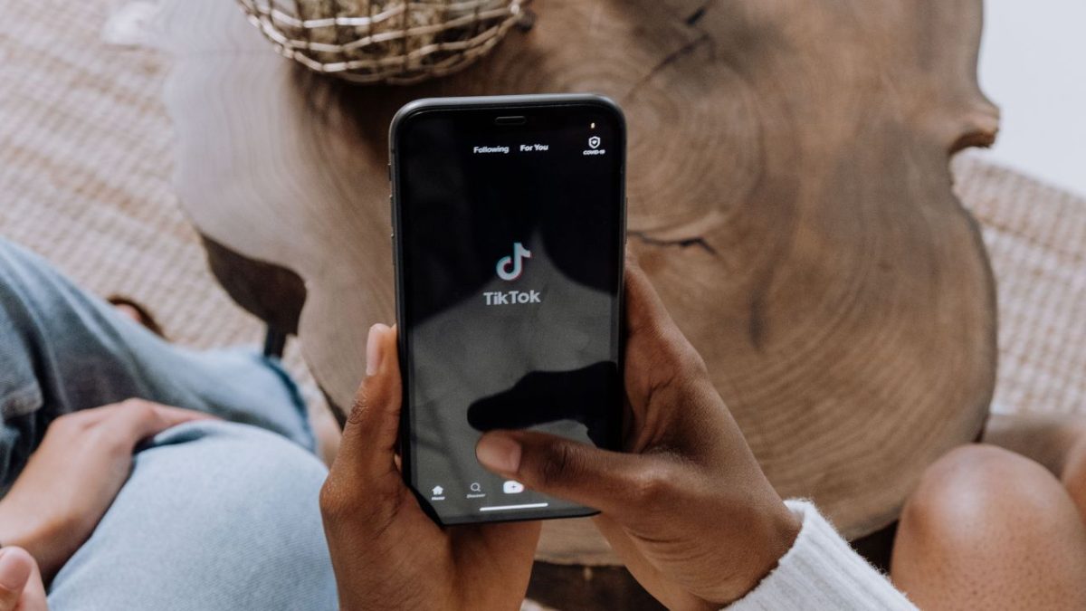 Ilustrasi aplikasi TikTok di layar ponsel yang digunakan untuk membuat konten promosi melalui program TikTok Affiliate dengan bantuan teknologi AI video generator. (Sumber: Pexels/cottonbro studio)